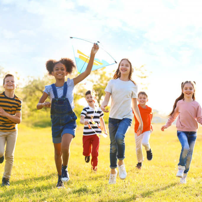 Cute little children playing with kite outdoors on sunny day comment adapter l'alimentation de mon enfant ?