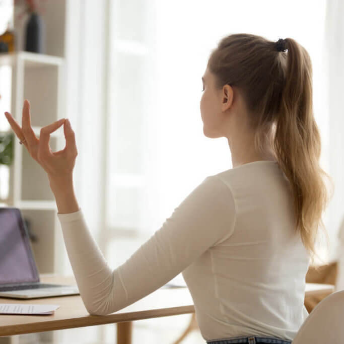 Focused female practice yoga at home desk biofar stress
